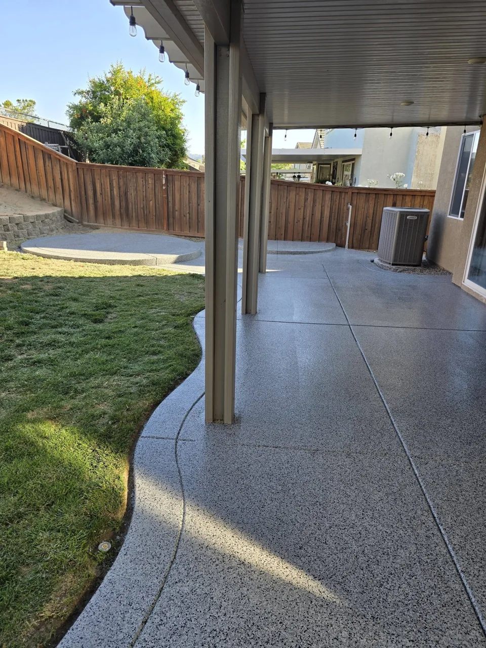 Coated backyard patio beneath a covered porch